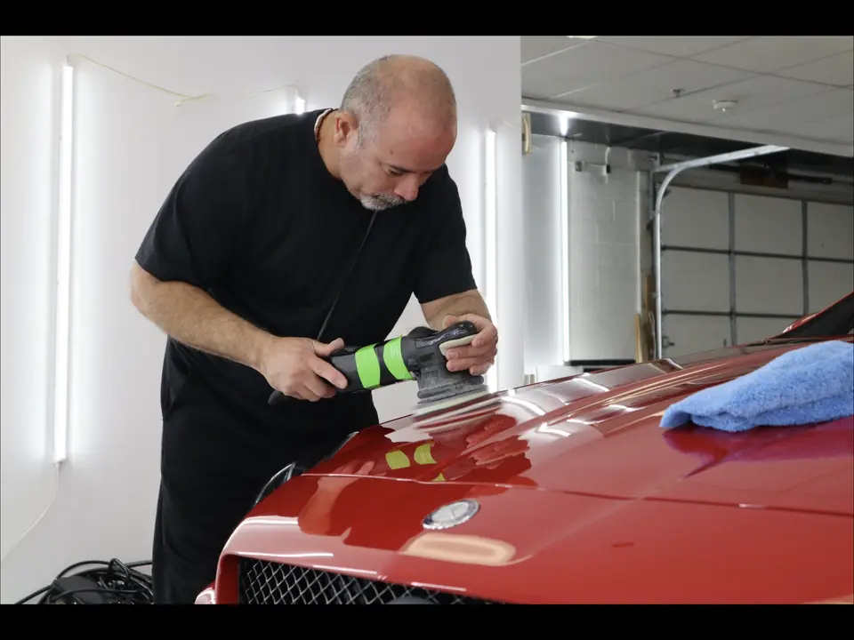 Machine polishing a red car