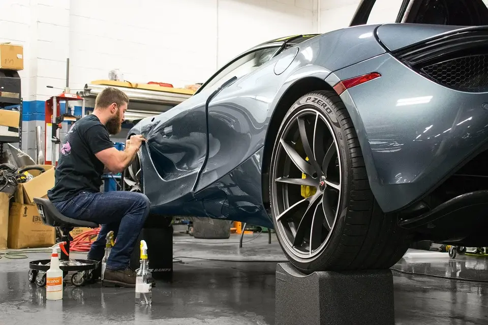 Installer fitting PPF on a McLaren rear quarter